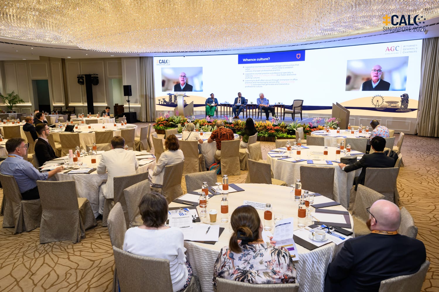 A wide shot of the ballroom at The Fullerton Hotel Singapore, with delegates at the Conference watching a video recording by Archie Zariski.